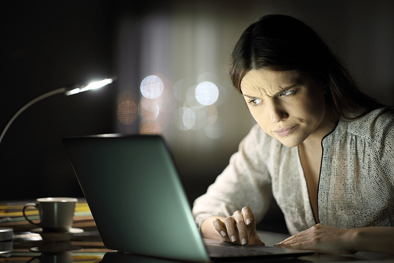 Woman showing distrust on laptop.